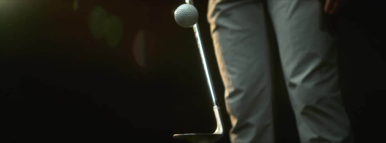A person bouncing a golf ball on a golf stick at morning