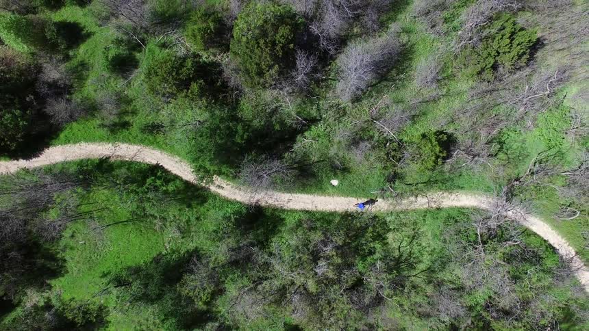 Aerial view of someone running up a small trail