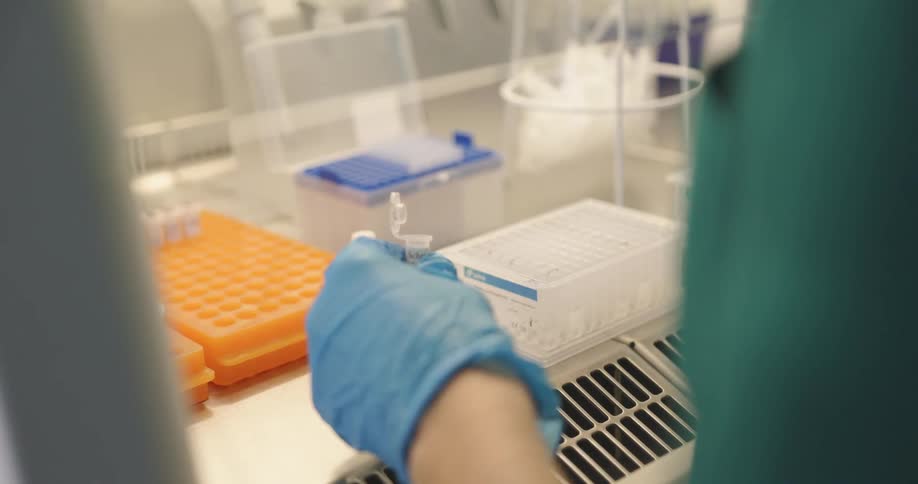 A lab technician is injecting into a test tubes