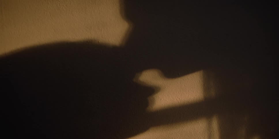 The shadow of a woman gives a man a kiss