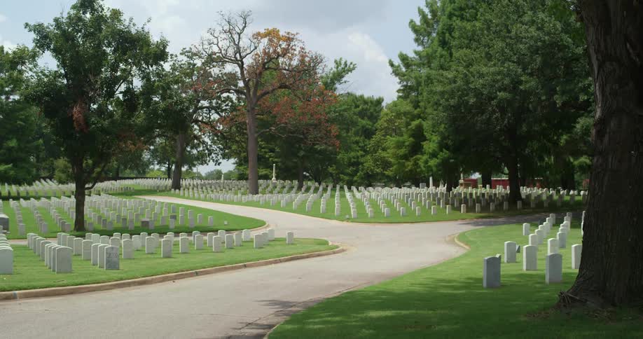 A well kept cemetery with many gravestones is shown