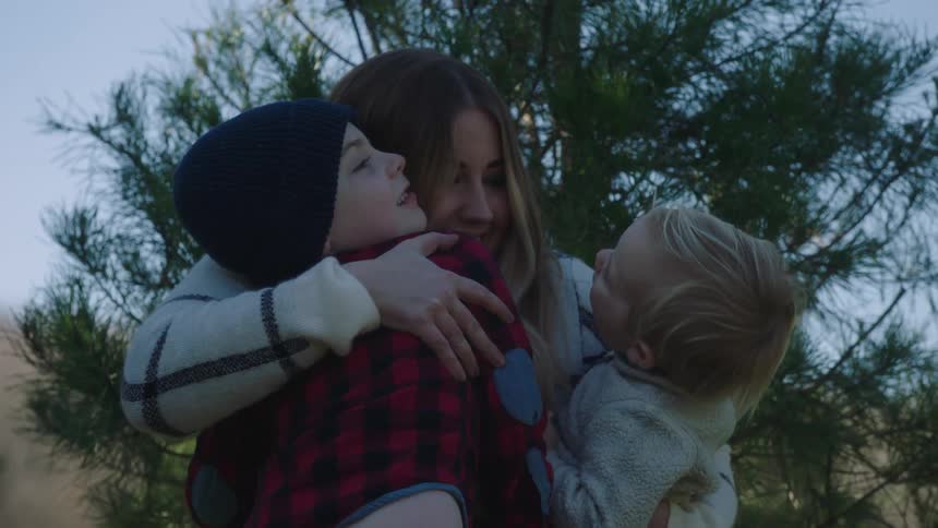 A family standing outside on a winter day and hugging