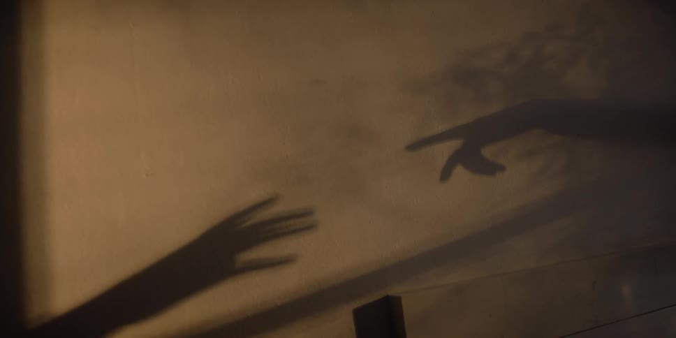 A view of two shadow hands touching