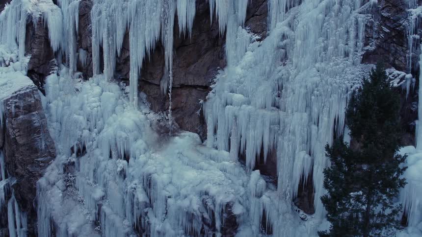 Huge icicles from frozen waterfalls alongside a cliff