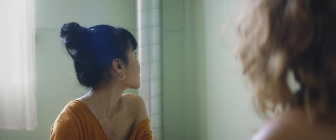 Two teenagers talk together and look around a room
