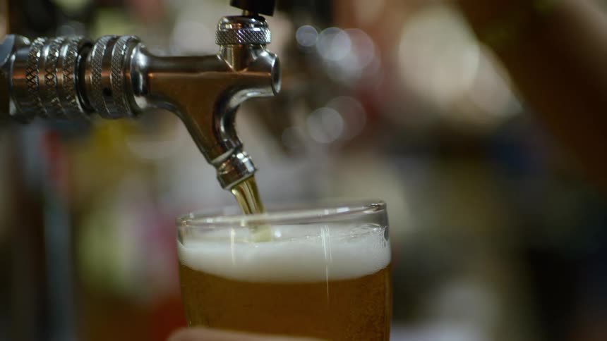 A close up of a beer being poured