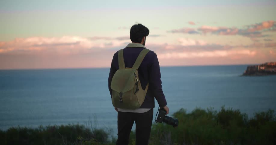 A man photographing the sunset at the ocean