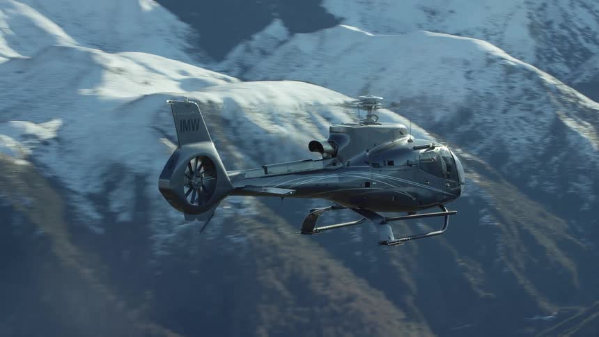 Helicopter flies over snowy mountains