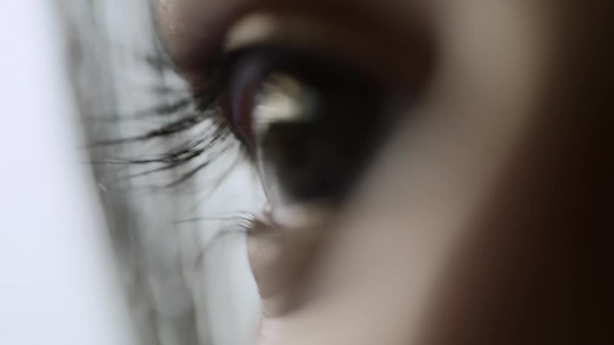 Woman with long lashes opens eye and looks around