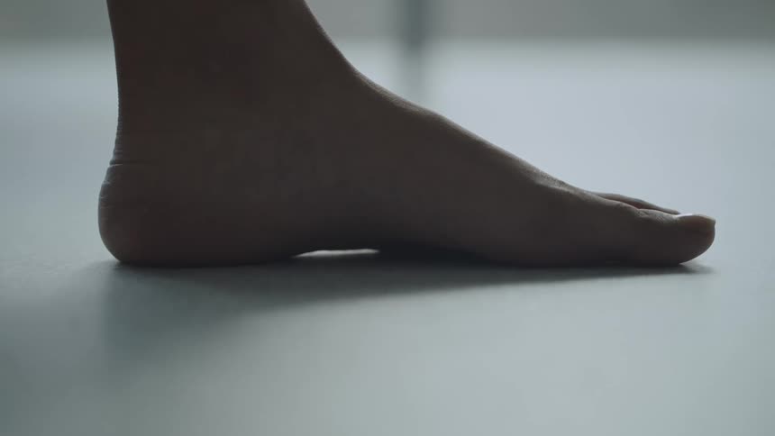 Bare foot of a woman over a white floor