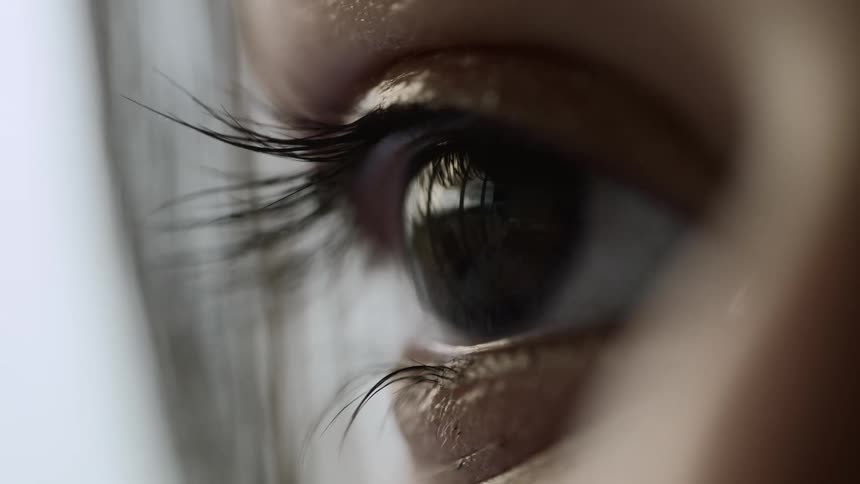 A young woman blinks her eyes