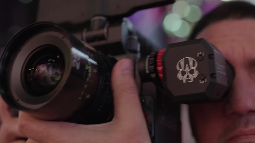 A man looking through a camera outdoors