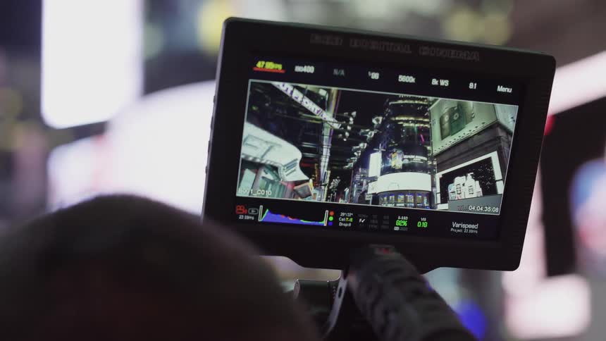 A camera man films city buildings and lights at night