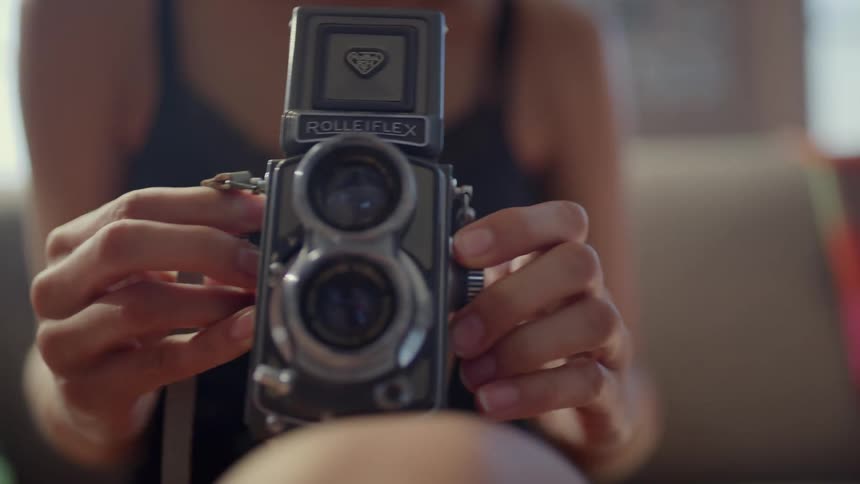 A view of a woman holding a camera in a room