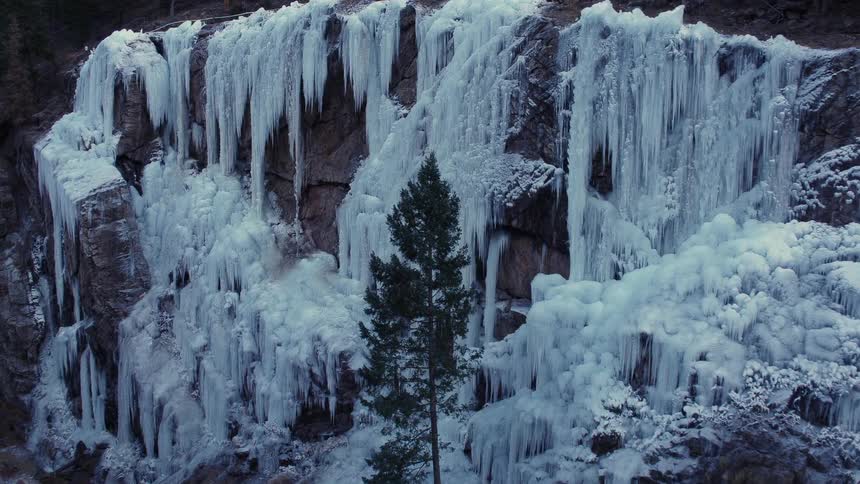 Frozen water falls alongside a cliff