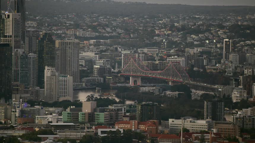 A city skyline with buildings skyscrapers and a bridge with the sky and clouds in the background