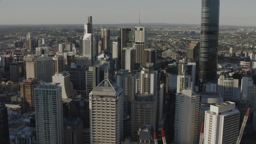 An aerial view of a downtown area in a city filled with high rise office buildings and construction cranes