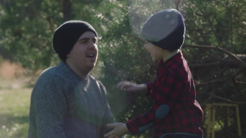 Father and son spending time together in a yard on fall season day