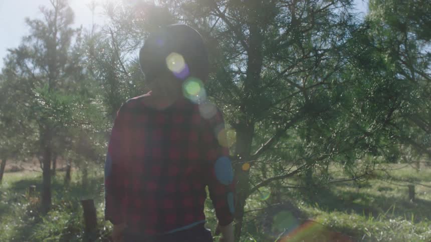 A young boy walks through a rural tree filled area by himself