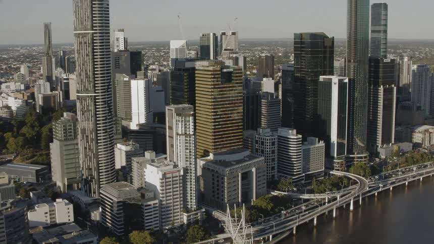 An aerial view of a city with office buildings and cars driving along the coast