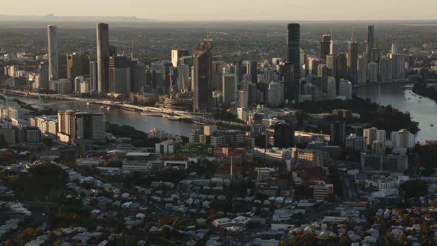 Aerial view the skyline of a city with a river at sunset