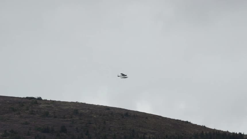 A small airplane takes off in a cloudy sky