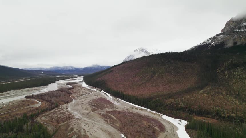 Aerial view of snow covered mountain peaks surrounding a valley
