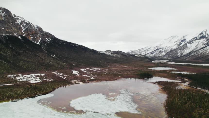 An aerial view of an icy mountain lake on an overcast winter day