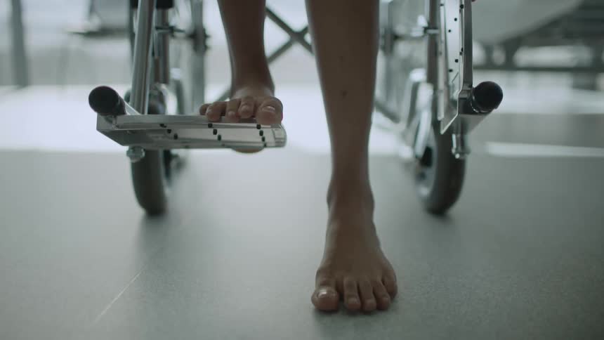 A person in a wheelchair trying to stand