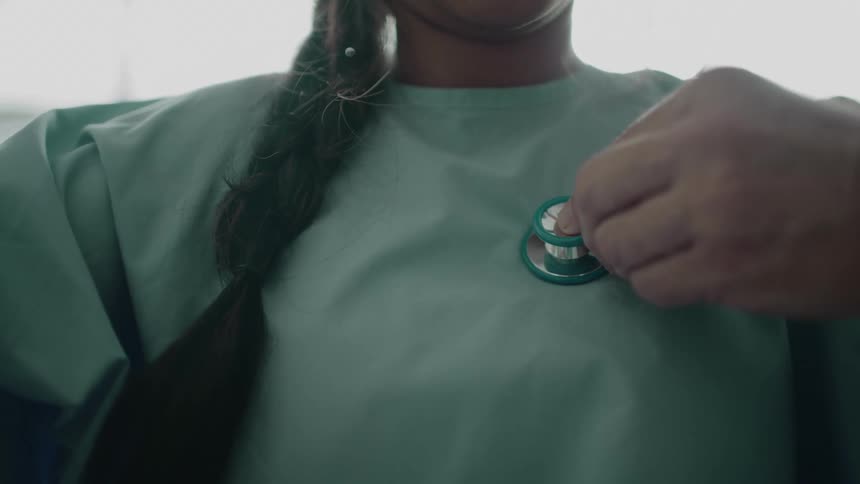 A doctor presses a stethoscope to a patients chest