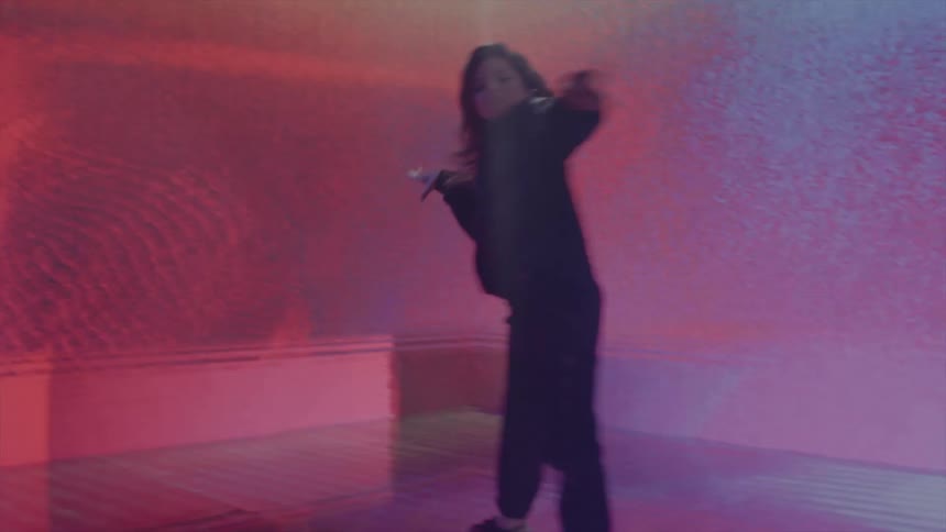 Woman dances in a room with multi colored walls