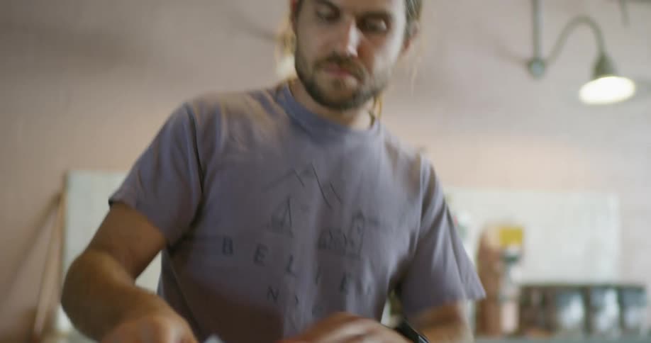 A man affixes a label to a cardboard package he is preparing for shipping