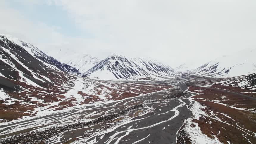 Aerial view of a snow streaked valley in the mountains