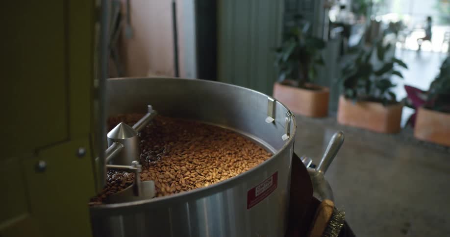 Coffee beans being roasted inside a machine on a coffee shop