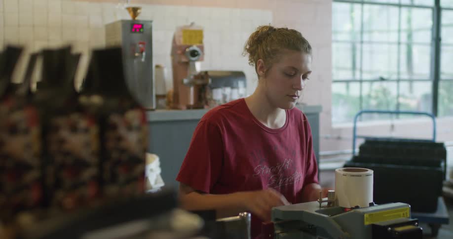 Young woman working on a coffee grounds packing warehouse