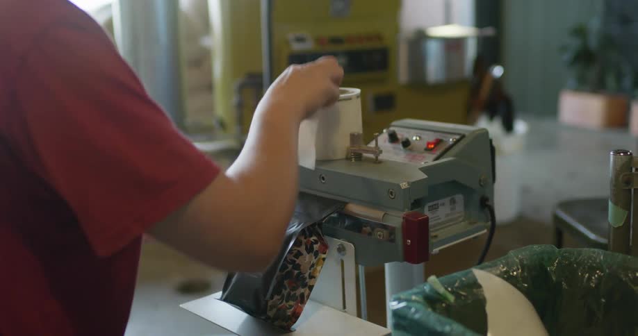 A person sealing a bag of coffee grounds