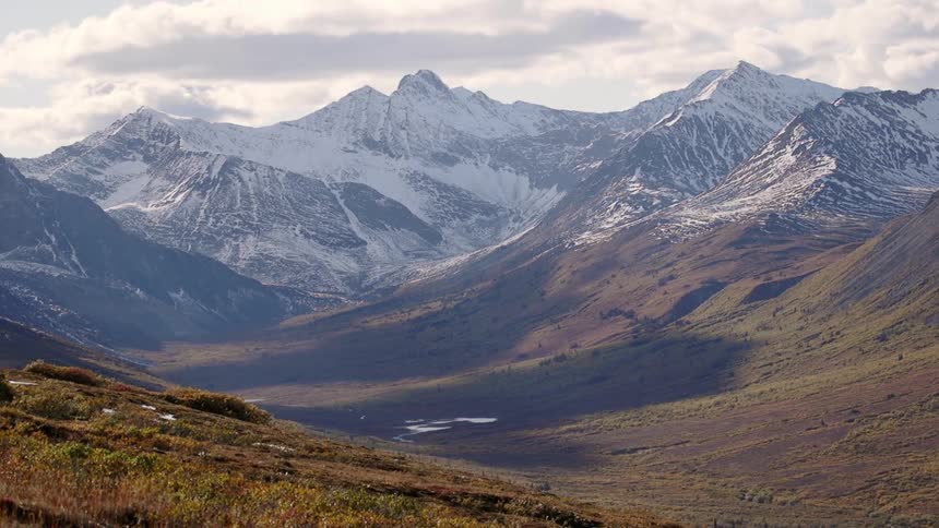 A mountain range is partially covered with snow