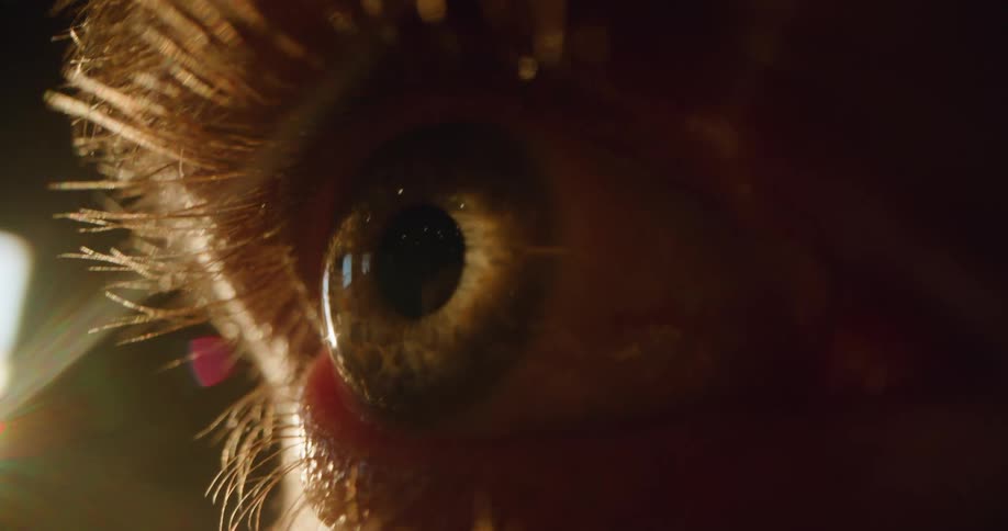 Extreme close up of a person long eyelashes and frantically moving eyeball