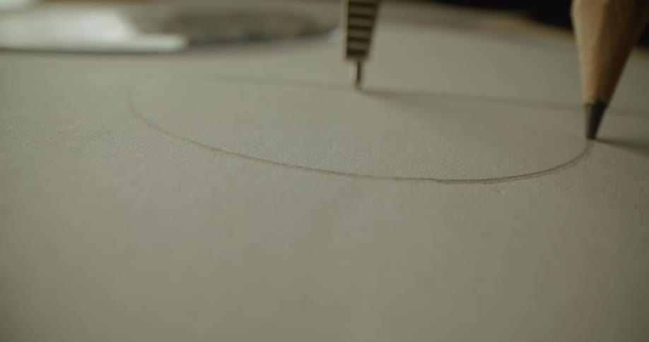 A view of a person drawing a circle with a compass