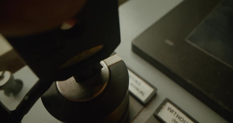 A person putting a key into a button on a control panel