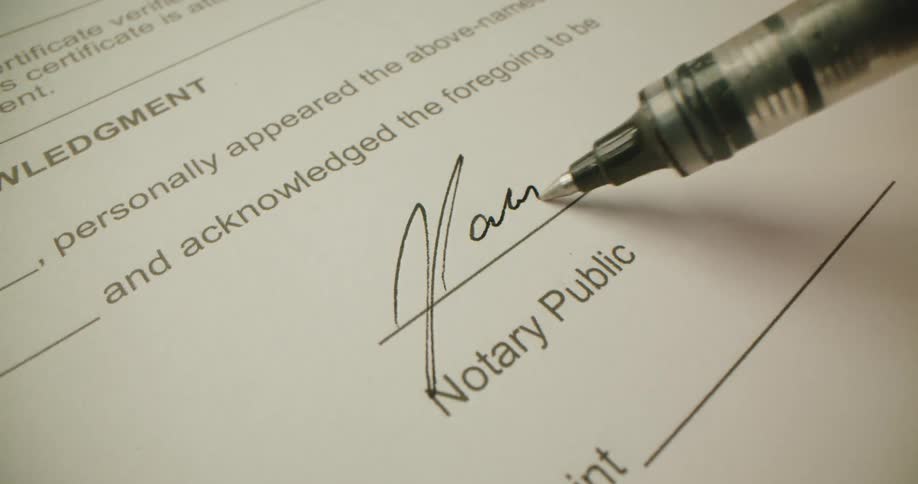 Person signing a legal document with a pen