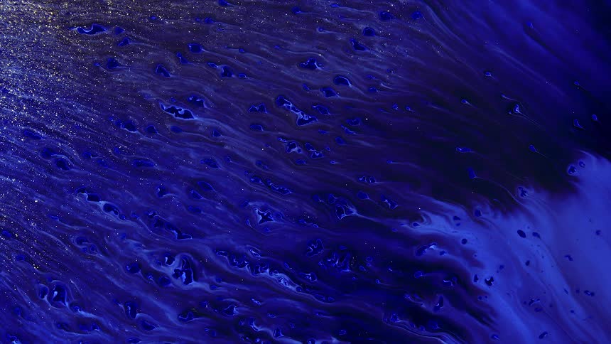 Waves and streaks of bright blue gold shimmering flowing liquid ink