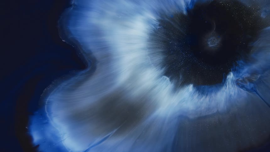 White and blue tendrils expand against dark blue black background leaving ring at center