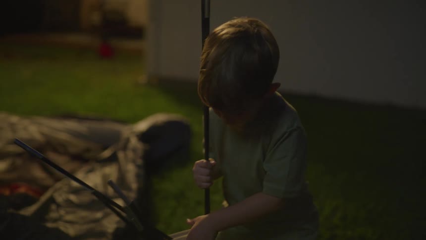 A child putting together a tent outdoors