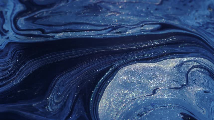 Flowing glitter blue paint creates and otherworldly scenery