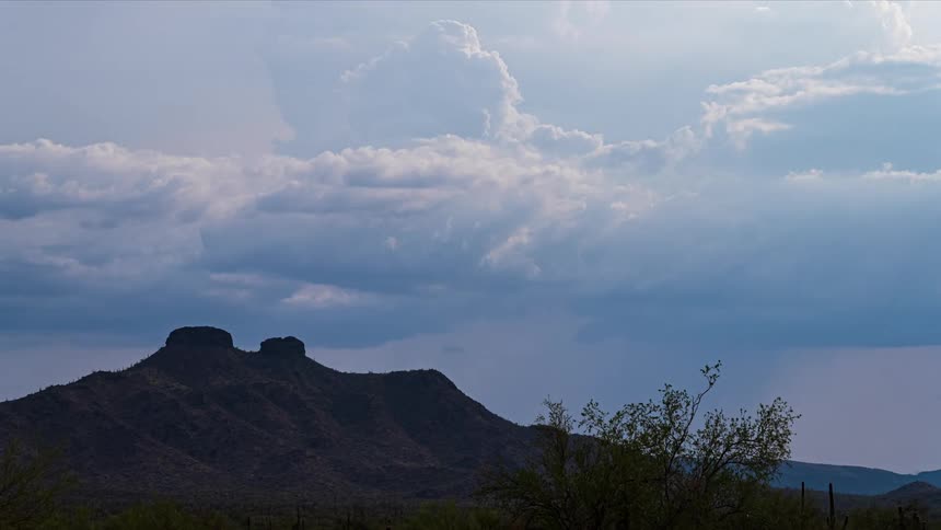 Time lapse of rain falling over the mountains in the desert at evening