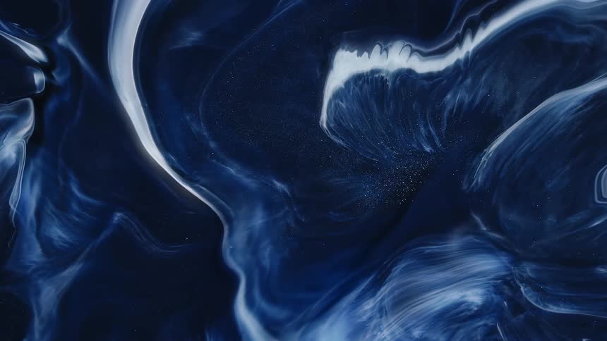 A close up of white liquid reacting violently with the blue liquid