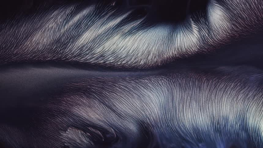 Iridescent purple and blue colored mass expands and spreads