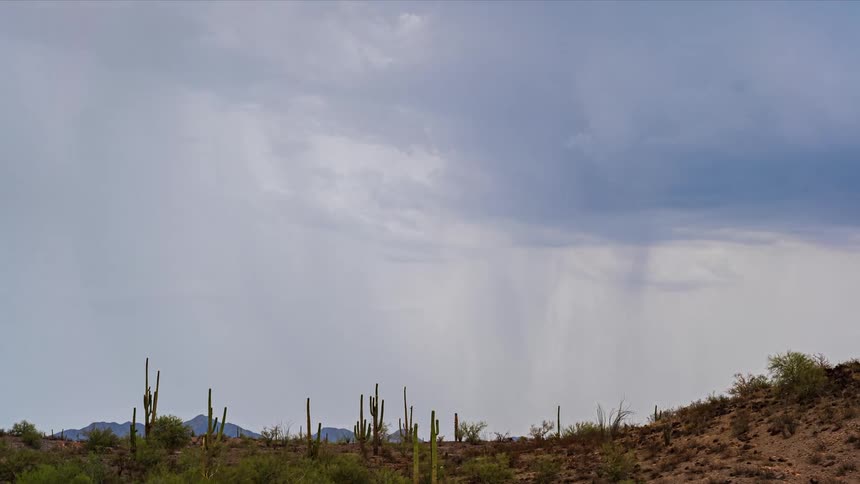 Storm clouds dump rain on a desert ridge