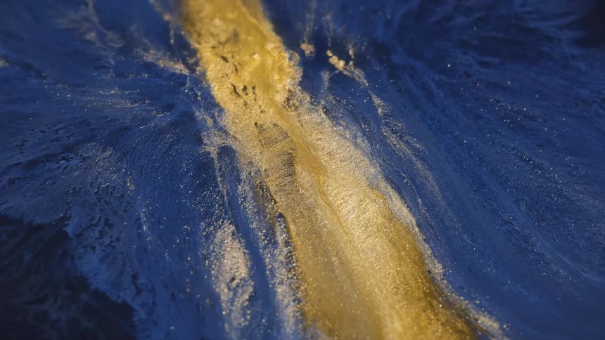 A stream of golden ink flows like a river and rotates